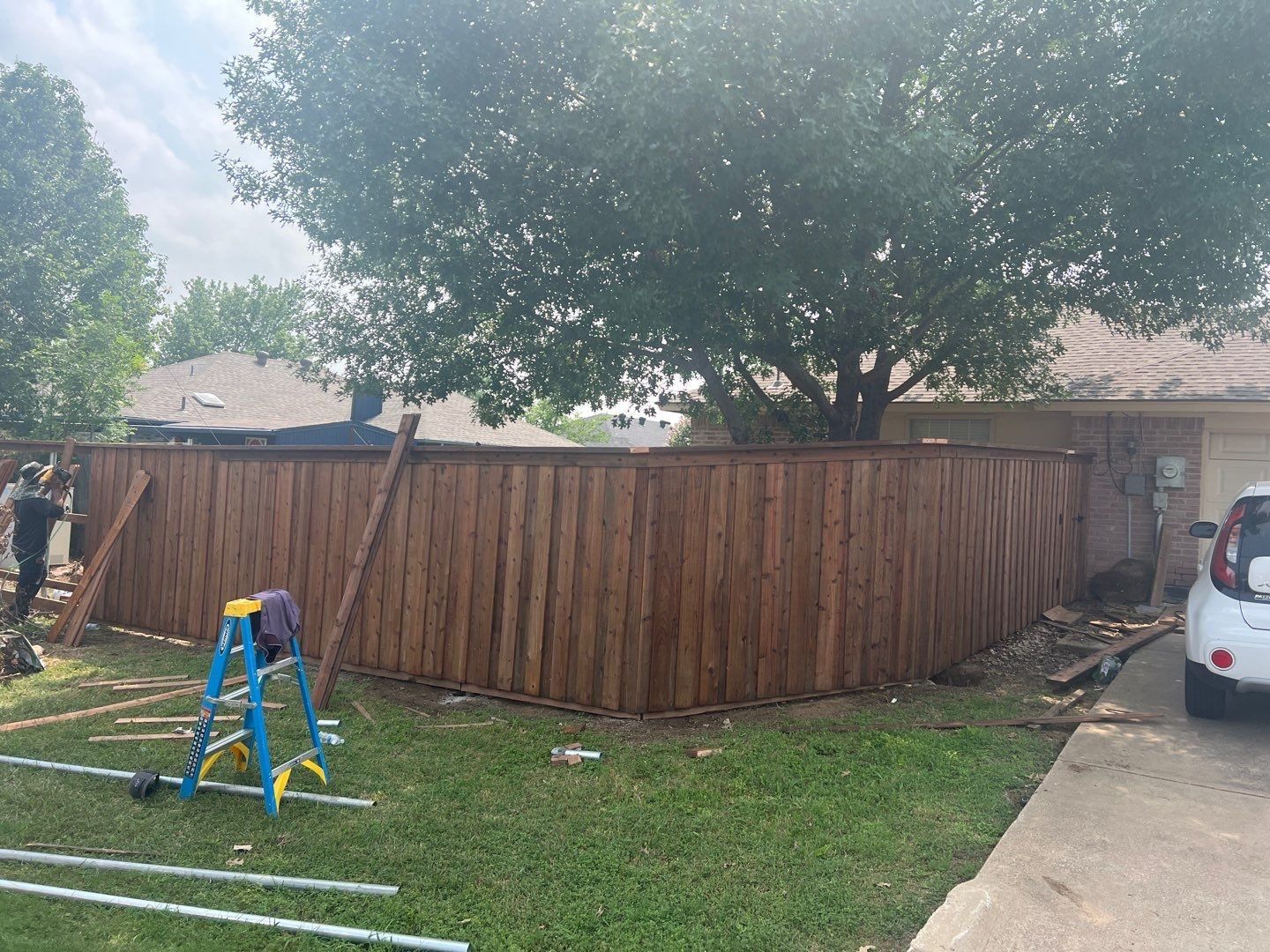 Board-on-board cedar privacy fence wrapping a corner of a Texas home