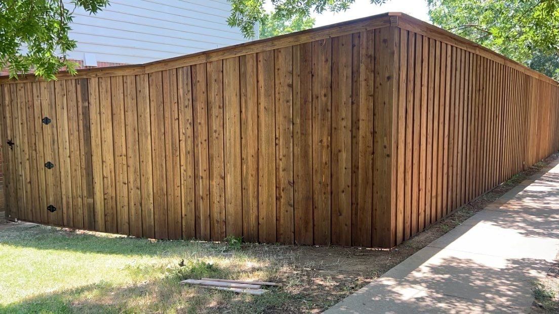 Board-on-board cedar fence with cap rail and trim, corner section
