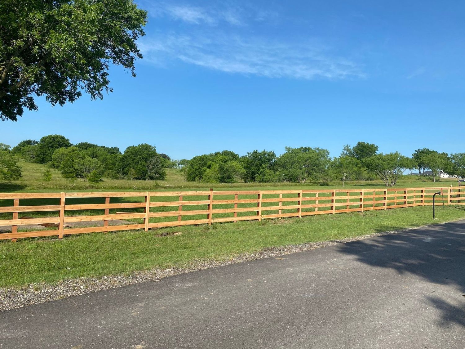 Wood ranch rail fence lining a North Texas pasture