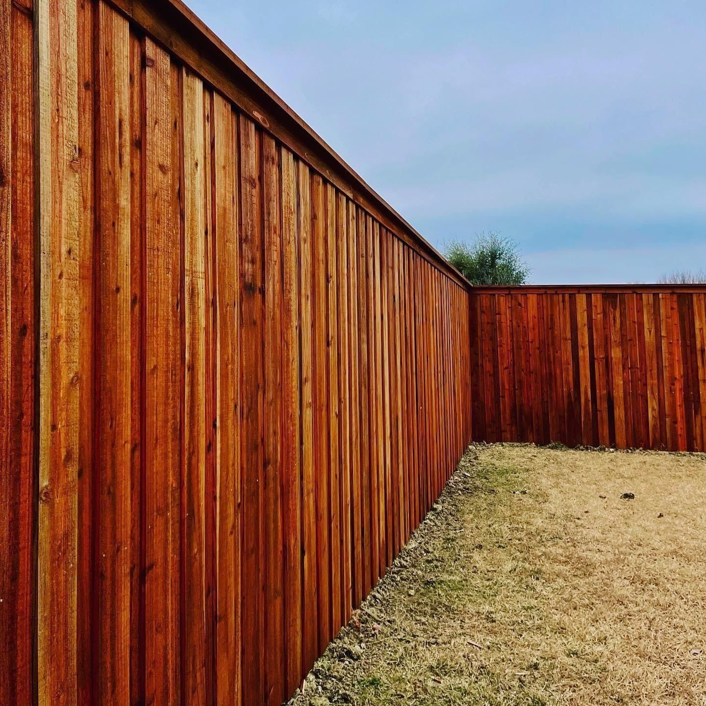 Stained cedar privacy fence with cap and trim installed in a DFW backyard
